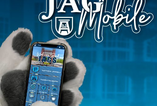 Augustus holds a phone with the words Jag Mobile written on the top of the photo