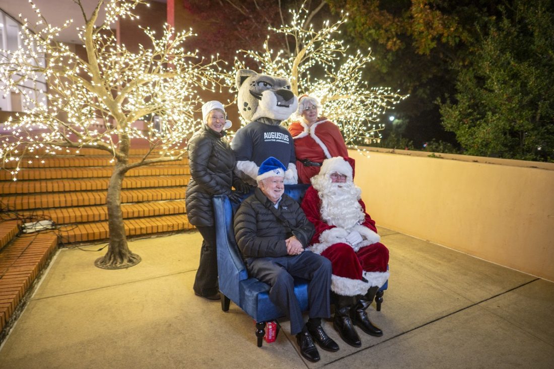 Men and women pose with Santa and Mrs. Claus