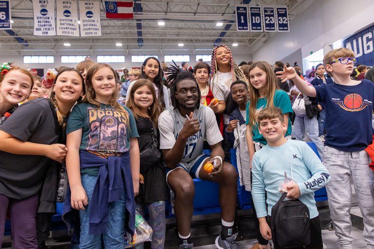 Basketball player smiles sitting near children