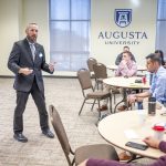 Professor speaks to students in a conference room