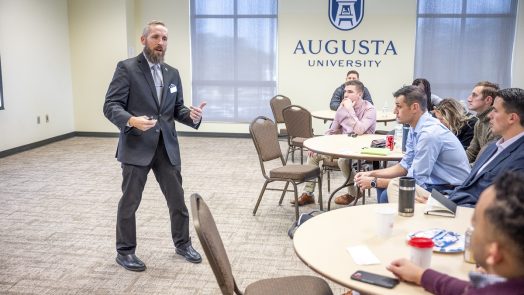 Professor speaks to students in a conference room
