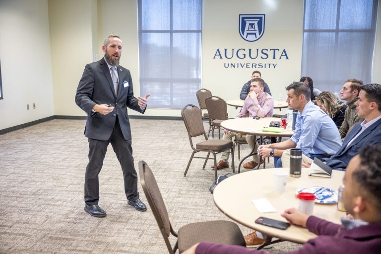 Professor speaks to students in a conference room