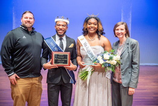 Mr. and Miss Augusta University standing with Augusta University staff members