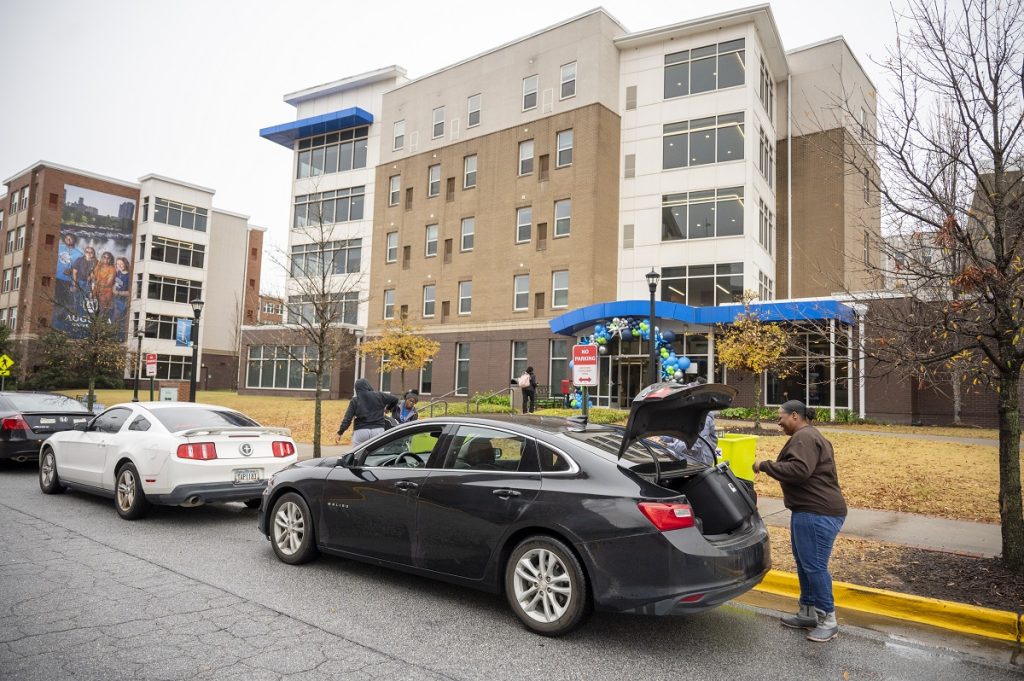 People unload their car in front of an Augusta University dorm 