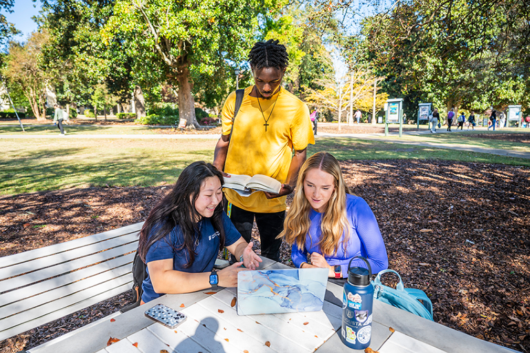 Three students looking at a computer on the Summerville Campus at Augusta University.