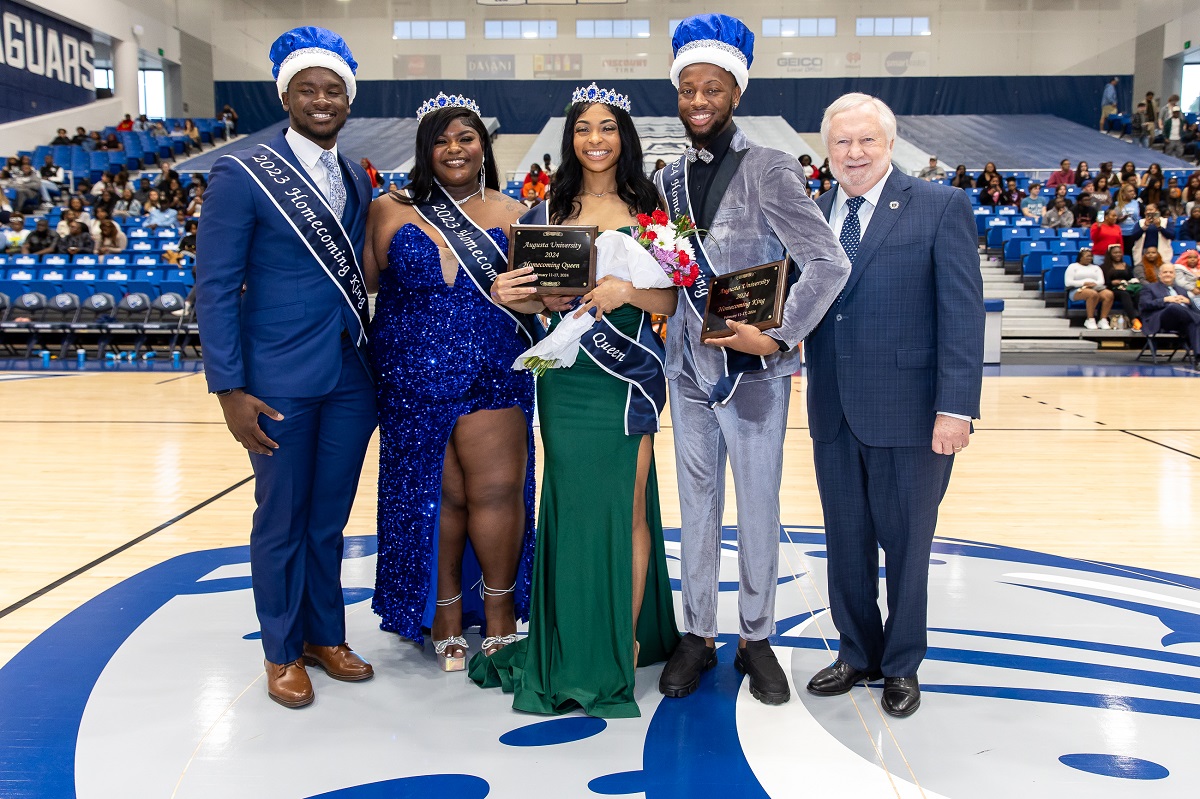 Past homecoming king and queen are with the new homecoming king and queen as well as the Augusta University president