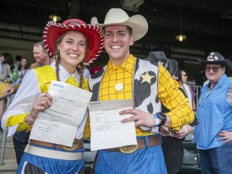 A couple dress up as Woody and Jessie from Toy Story for Match Day as they open their envelopes for their residency