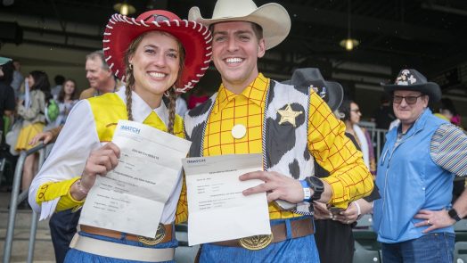 A couple dress up as Woody and Jessie from Toy Story for Match Day as they open their envelopes for their residency