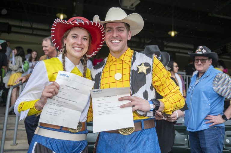 A couple dress up as Woody and Jessie from Toy Story for Match Day as they open their envelopes for their residency