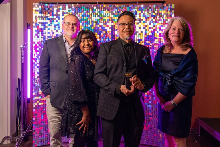 Men and women pose for a photo at an awards ceremony