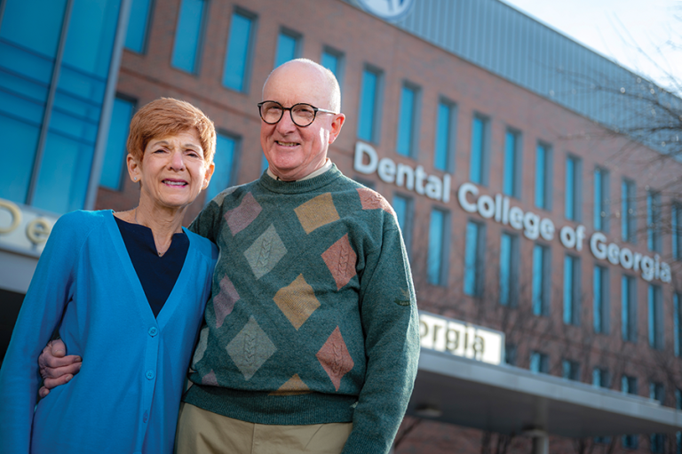 A man and a woman stand in front of a building.