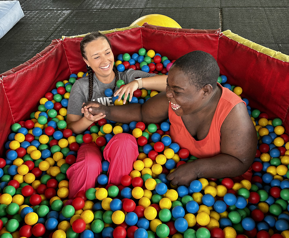 A female student plays with a female student in a ball pit