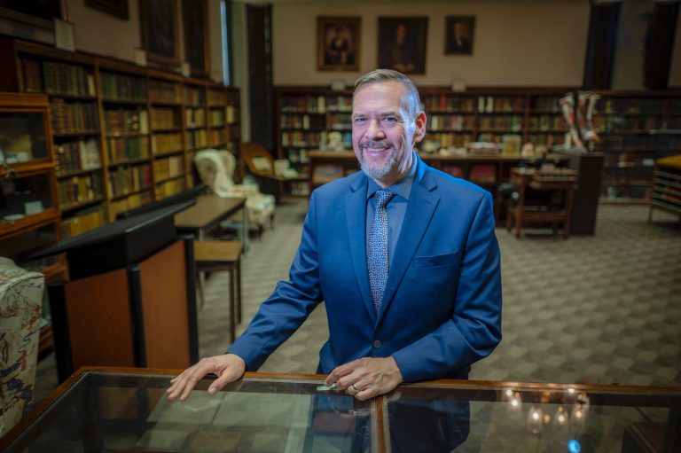 Man smiles for camera in library.