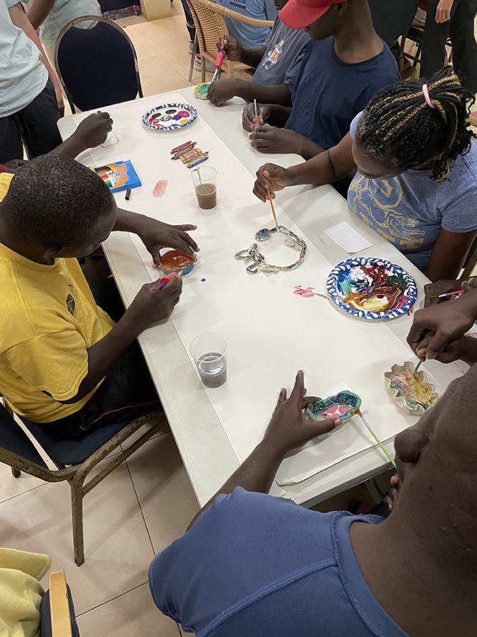 A group of residents sit around a table working on arts and crafts