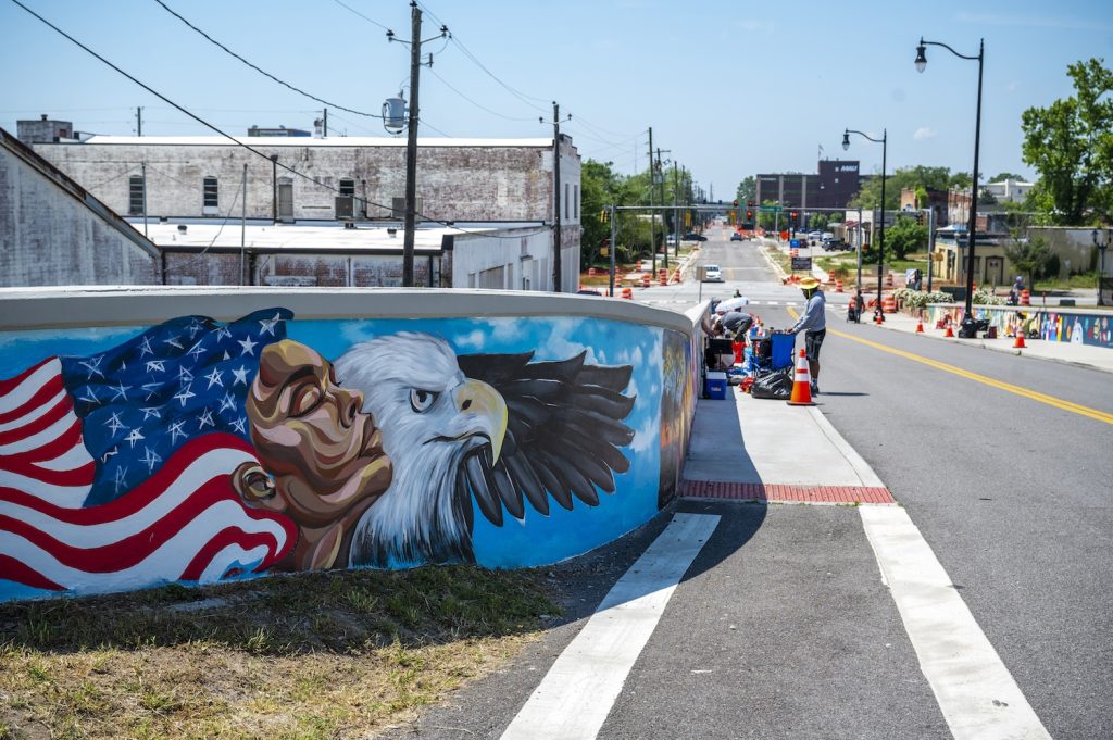 A mural depicting a woman whose hair is the American flag next to a bald eagle.