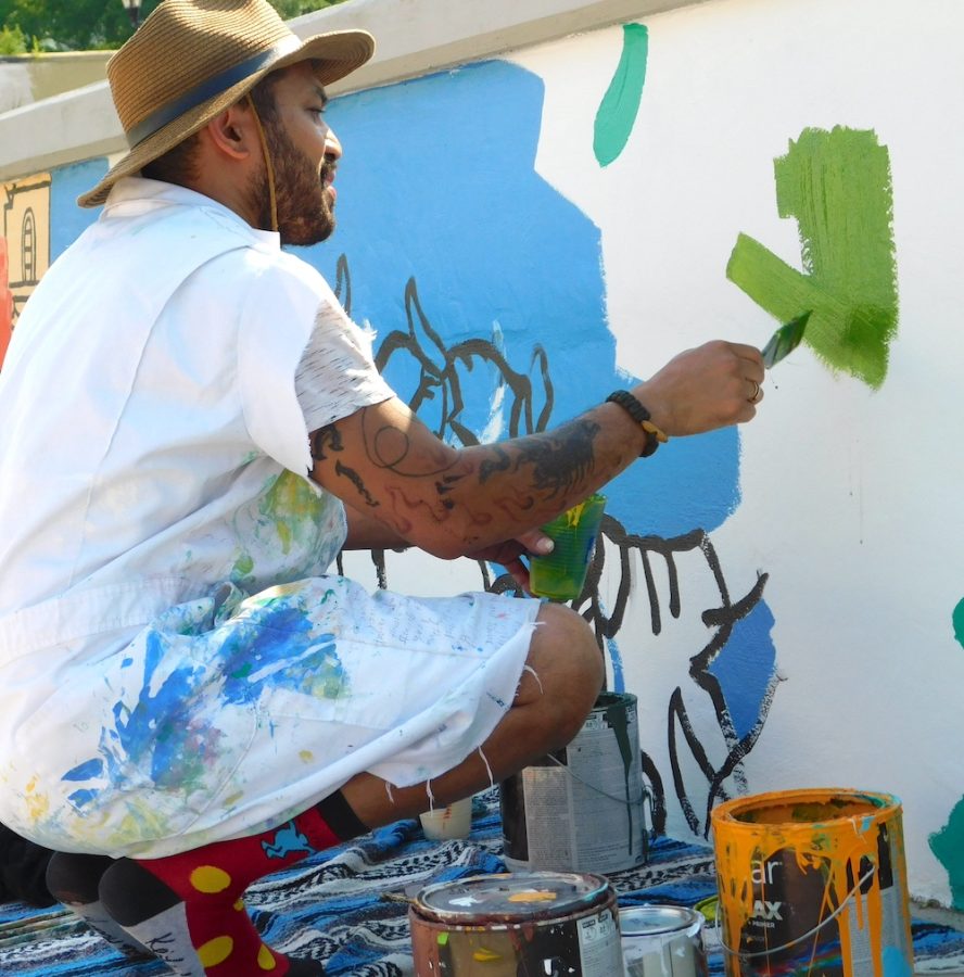 Man painting an outdoor mural.