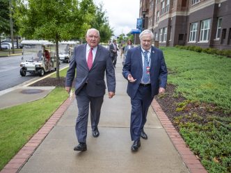 University System of Georgia President Sonny Perdue walks with Augusta University President Brooks, A. Keel