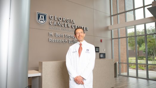 Male smiling and standing inside building