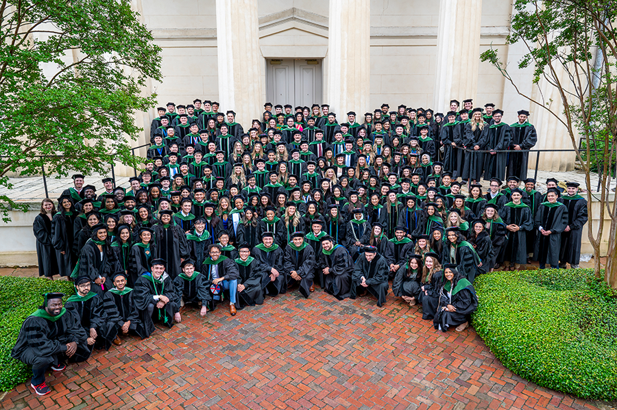 Two hundred and fifty recent medical school graduates pose for a large photo on the steps of an historic building.