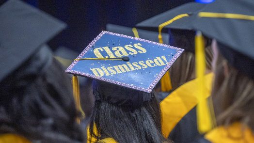 A graduation cap with the words "Class Dismissed!" written on it.