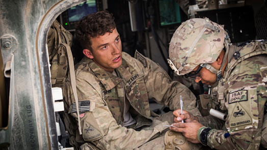 Soldier receives aid sitting in helicopter