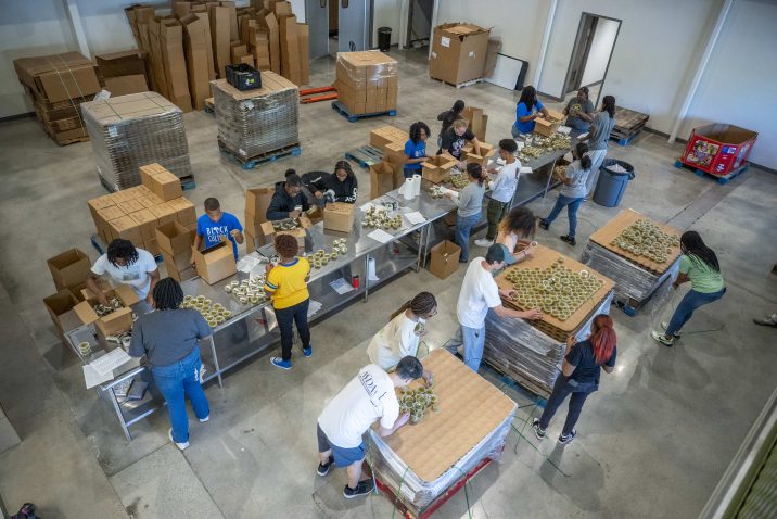 More than 20 students sort items at a food bank.
