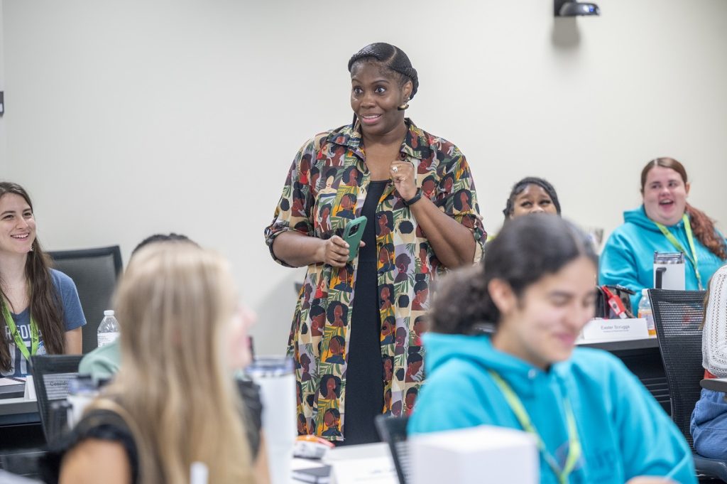 woman talks to other young ladies in a classroom