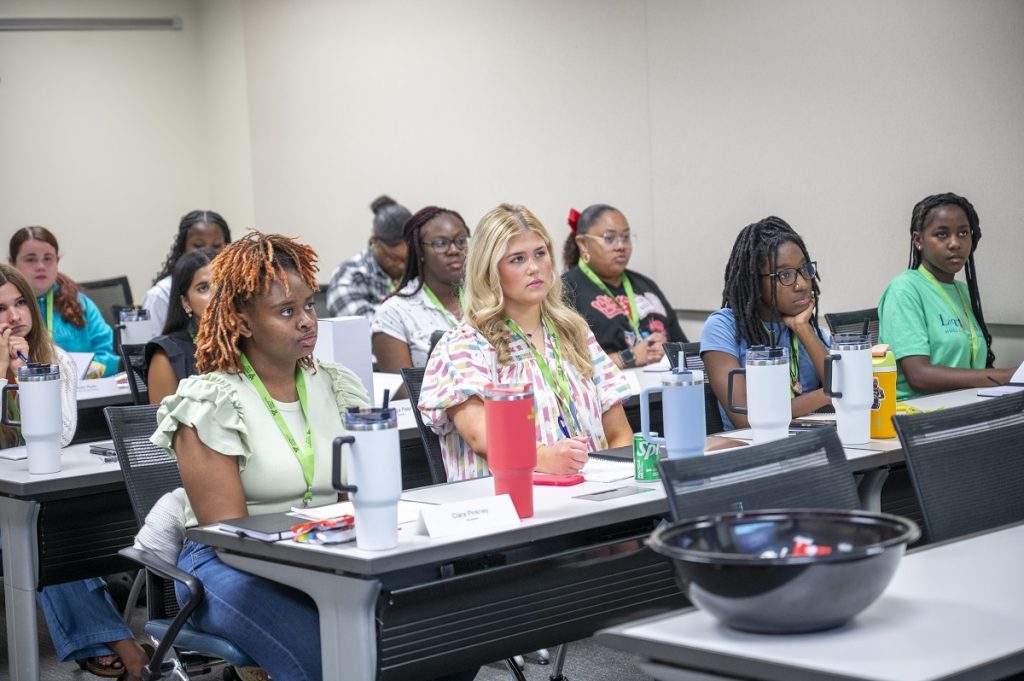 Young ladies listen intently in a classroom