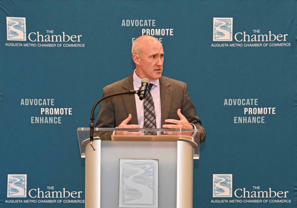 Man in a suit talking at a podium.