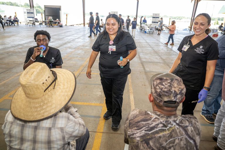 Three women demonstrates techniques to farm workers