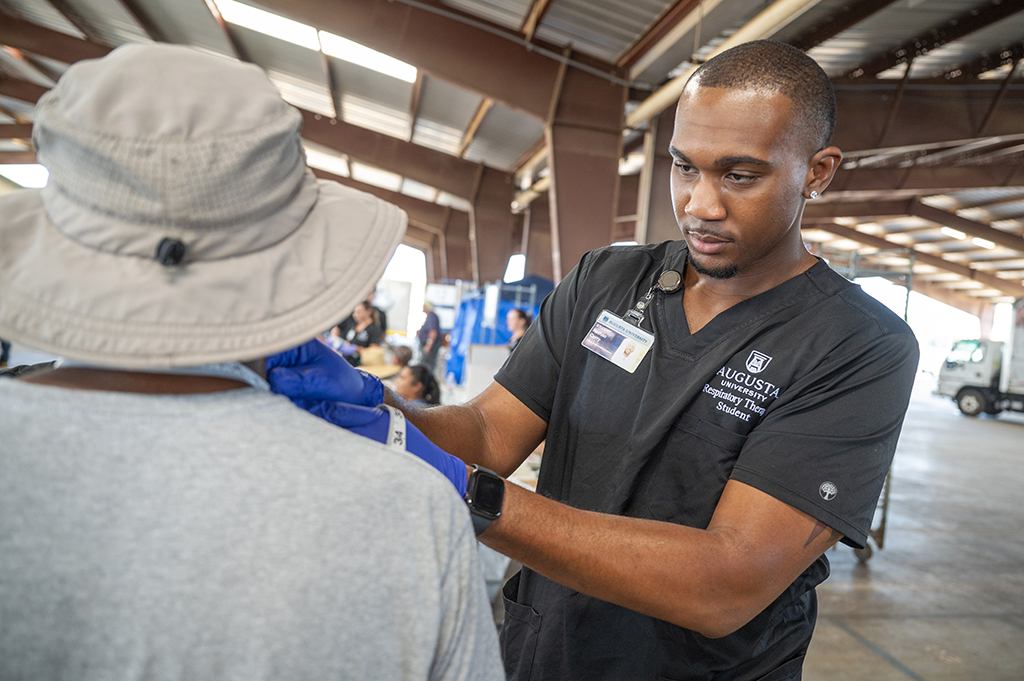 Man conducting a medical exam on a farm worker