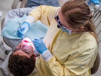 Dental Hygiene student working on a patient's teeth