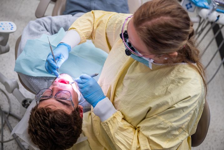 Dental Hygiene student working on a patient's teeth