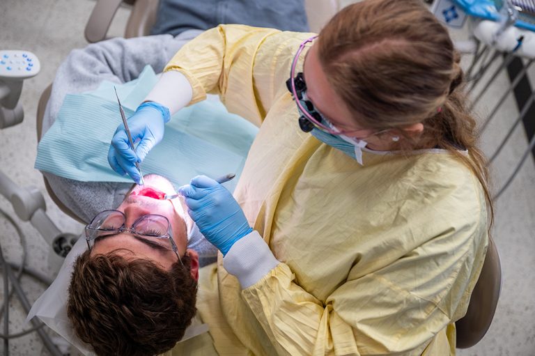 Dental Hygiene student working on a patient's teeth