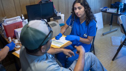 Female student helping a man with testing