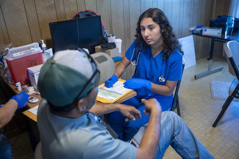 Female student helping a man with testing