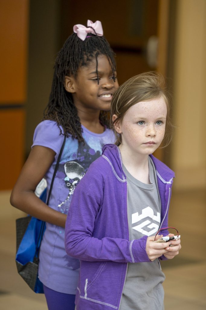 Two young girls try to navigate a course with their microbot, a form of radio-controlled car.