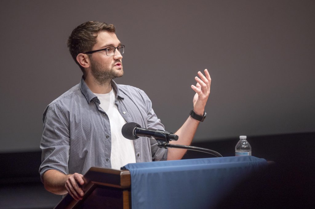 A man delivers a presentation at a podium.