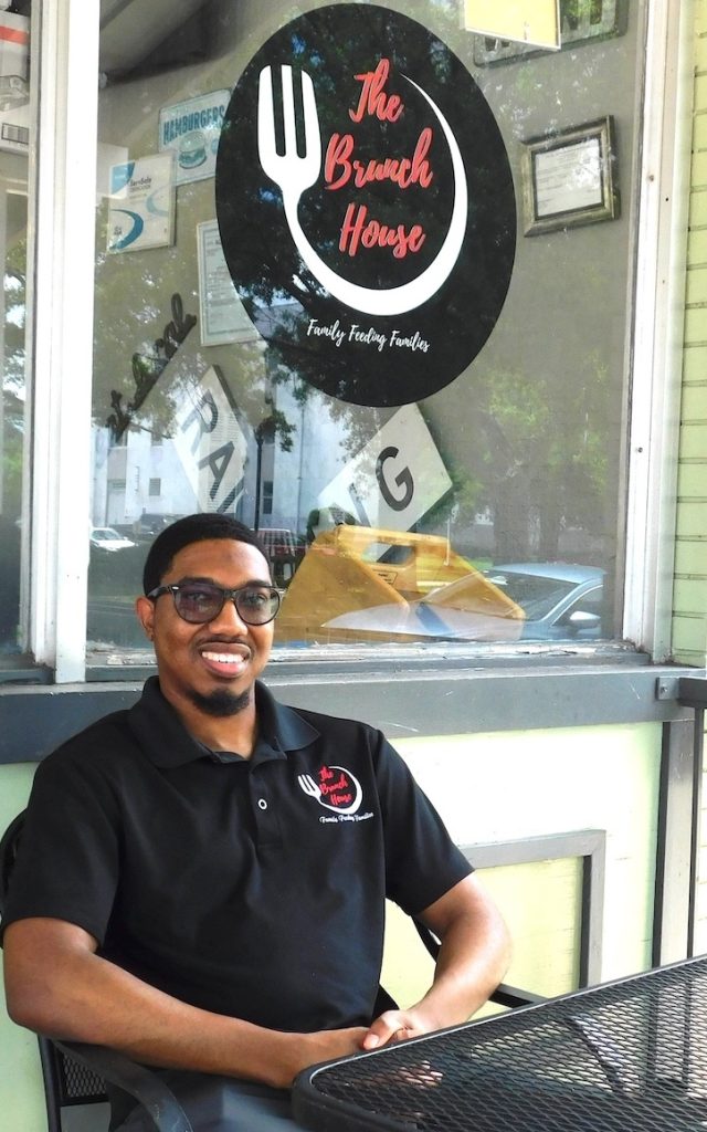 Owner sitting outside his restaurant.