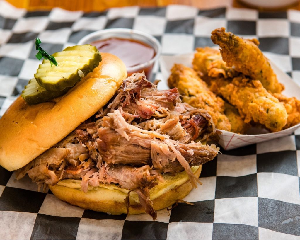 Barbecue sandwich with a side of fried pickle spears.