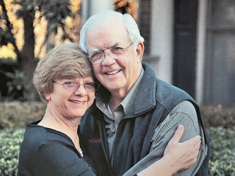 A man and a woman hug each other outside.