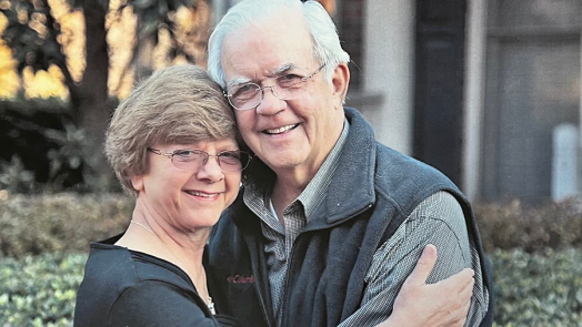 A man and a woman hug each other outside.