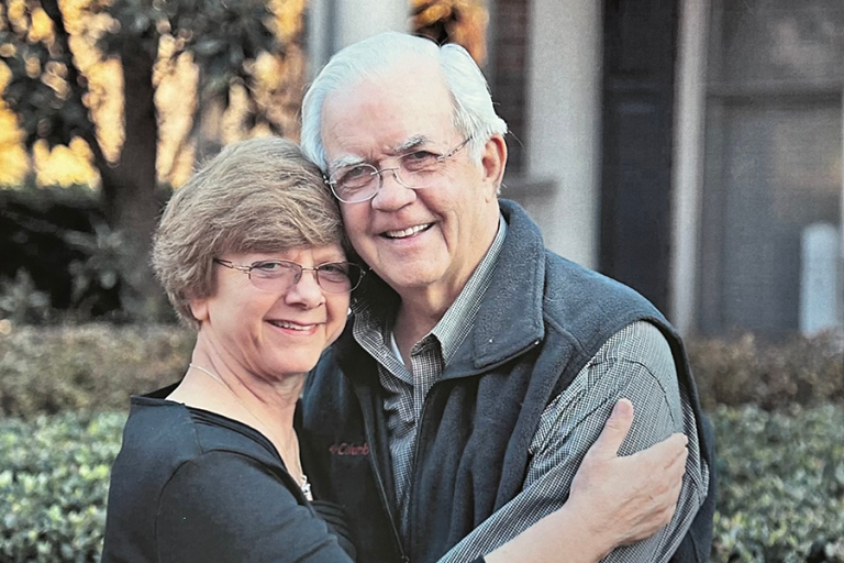 A man and a woman hug each other outside.