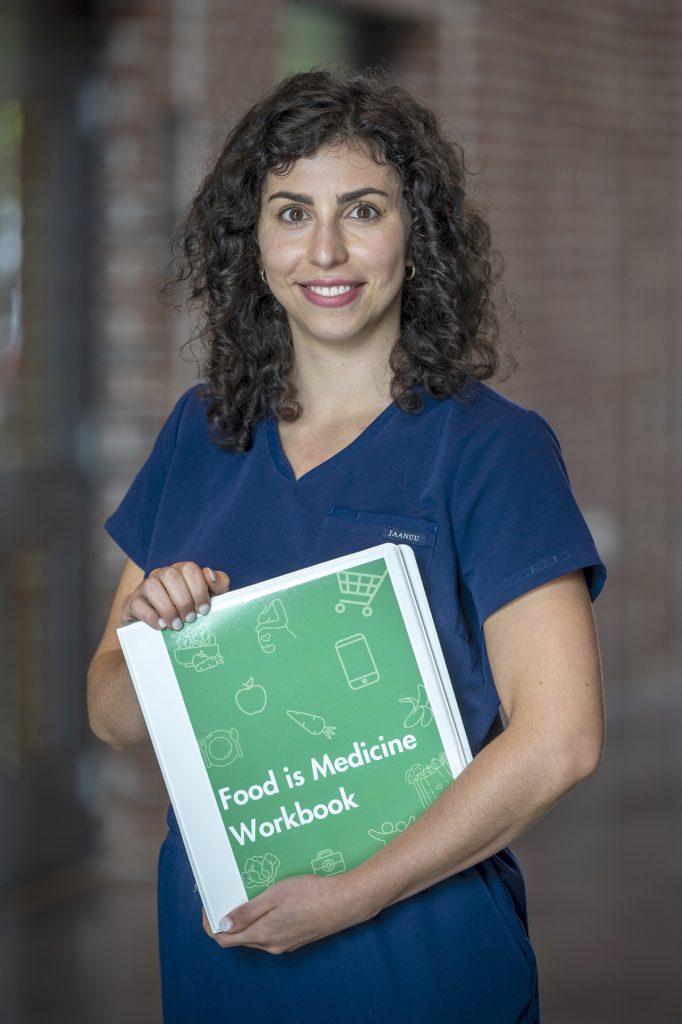 A medical student poses with a workbook in her hand