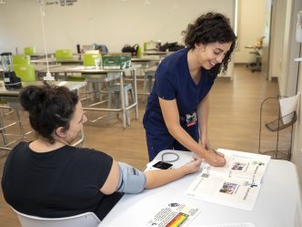 A medical student works with a soon to be mother and enters information into a workbook