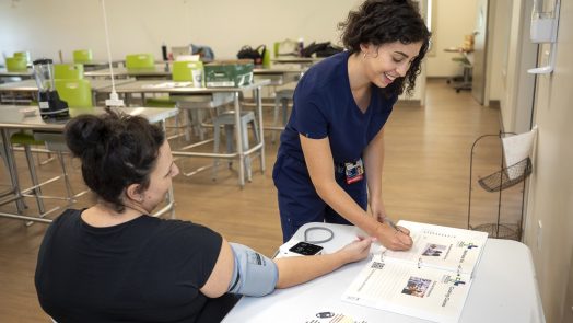 A medical student works with a soon to be mother and enters information into a workbook