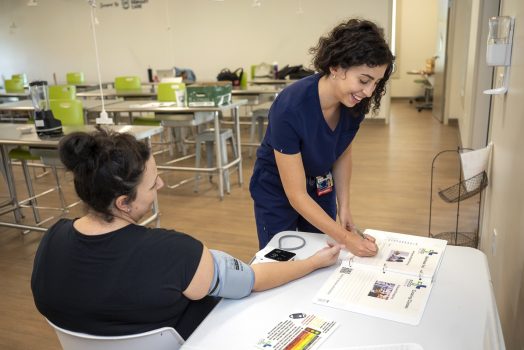 A medical student works with a soon to be mother and enters information into a workbook