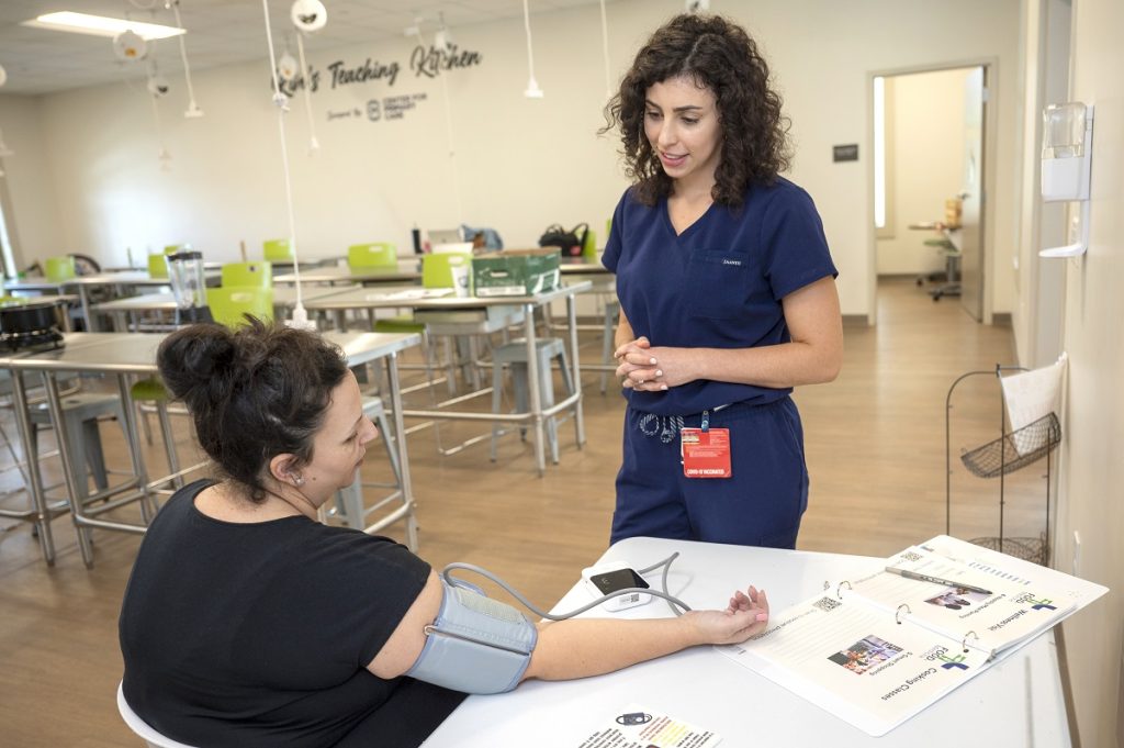 A medical college student takes the blood pressure of an expectant mother.