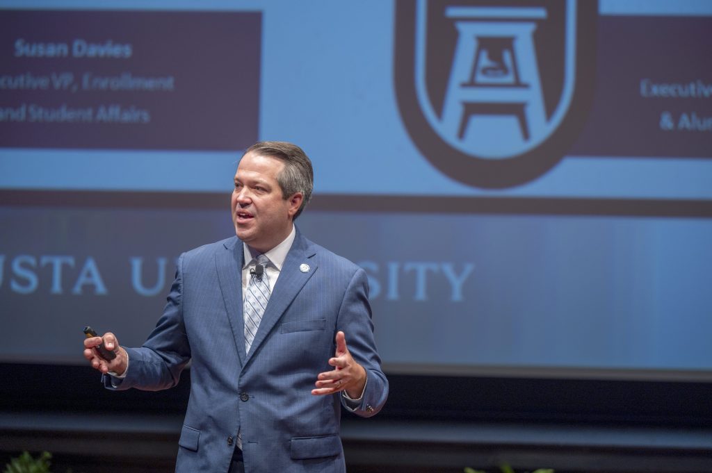 A man delivers a presentation on a stage.