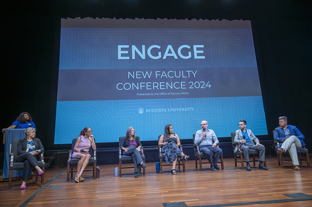 Men and women sitting and talking on stage.